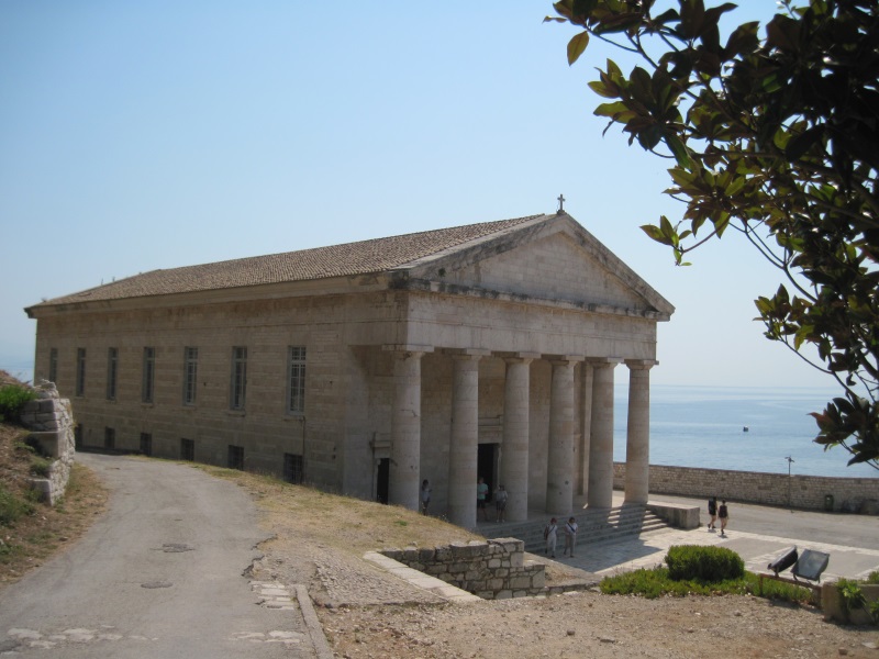 Neoclassical Saint George's church within the Old Fortress in Corfu Town stands by the sea and offers shelter from the sun.