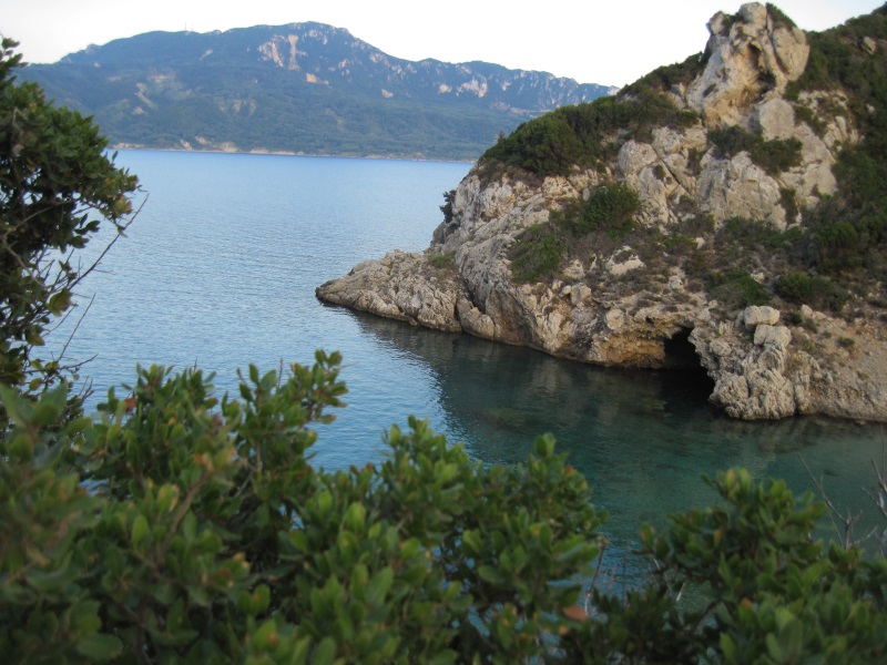A tiny cove of Porto Timoni Beach with clear waters accesses a bay edged by the Corfu Island's high hills, the Ionian Sea.