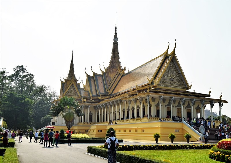 Throne Hall of the Royal Palace in Phnom Penh boasts Khmer architecture, a golden roof, and a Buddha face adorning the spire.