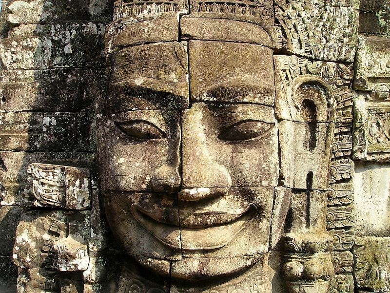 A large smiley face carved on the stone decorates an old Khmer temple in Angkor Archaeological Park near Siem Reap, Cambodia.