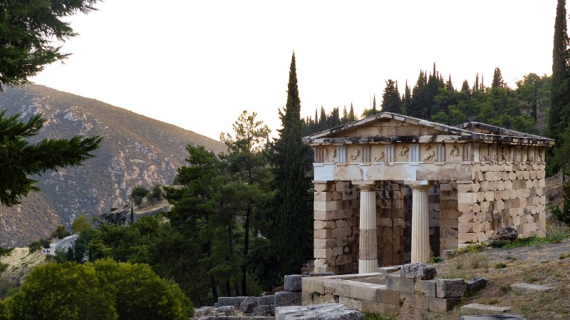 A Doric temple stands in the verdant environment of the mountainside in Delphi, where the oracle of Ancient Greece resided.
