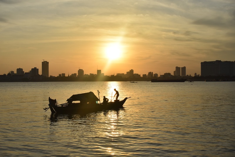 A fishing boat and the skyline of Phnom Penh make for an ideal photo session during the sunset over the Mekong River.