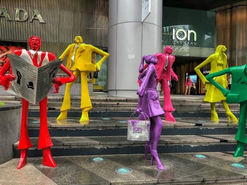 In front of Ion Orchard Mall, visitors can see sculptures depicting people carrying bags, reading the newspapers, etc.